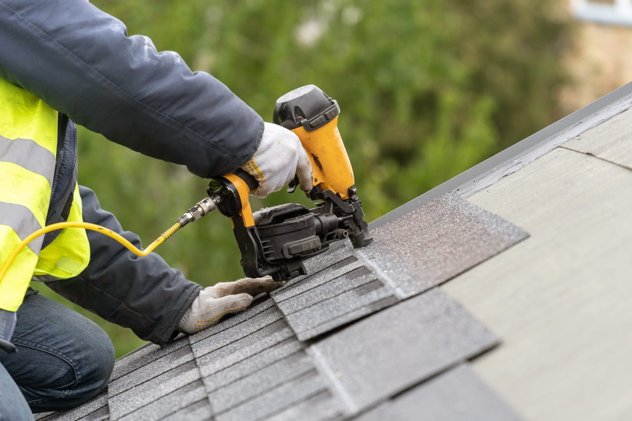 Close up of a contractor installing roof shingles
